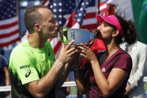 Soares of Brazil and Mirza of India kiss their trophy after defeating Gonzalez of Mexico and Spears of the U.S. in the mixed doubles final match at the 2014 U.S. Open tennis tournament in New York